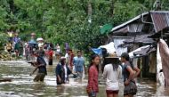 Villagers wade through a flooded street in Brgy Calingatngan, in Borongan, on easterm Samar in central Philippines on December 16, 2017. / AFP.