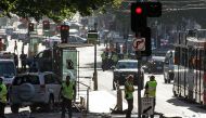 A white SUV (L) sits in the middle of the road as police and emergency personnel work at the scene of where a car ran over pedestrians in Flinders Street in Melbourne on December 21, 2017. / AFP.