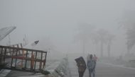 People walk along the Corniche shrouded in thick fog yesterday morning. Qatar is likely to witness another foggy morning today according to the Meteorology Department. Pic: Salim Matramkot/The Peninsula
