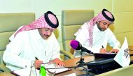 Dr Hassan Al Derham, President of Qatar University (right), and Faleh Al Naemi, Chairman and Managing Director of Qatar Post, signing the MoU. 