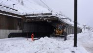 Workers clear snow from a train tunnel in Zermatt on January 9, 2018 after heavy snowfall and avalanches trapped more than 13,000 tourists at Zermatt, one of Switzerland's most popular ski stations. AFP / Mark Ralston
