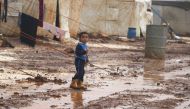 A Syrian kid walks around through mud at a refugee camp where many Syrians lived in, following the heavy rains in Idlib, Syria on January 18, 2018. (Alaa Fatravi - Anadolu Agency)