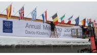 Workers fix a banner on the frontage of the congress centre, the venue of the upcoming World Economic Forum (WEF) in the Swiss mountain resort of Davos, Switzerland, January 18, 2018. REUTERS/Arnd Wiegmann