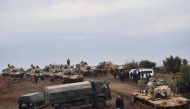 Villagers watch as Turkish army tanks and soldiers gather near the Syrian border on January 21, 2018 at Hassa, in Hatay province.  AFP / BULENT KILIC
