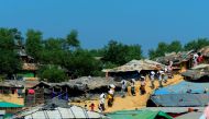 Rohingya Msulim refugees carry relief material at Kutupalong refugee camp in Bangladesh's Ukhia district on January 23, 2018. AFP / Munir UZ ZAMAN
