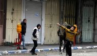 Palestinians hurl stones at Israeli troops during clashes in Hebron, West Bank, 23 January 2018.  EPA/Abed Al Hashlamoun