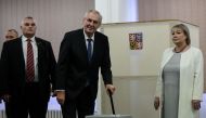 Czech President Milos Zeman (C) is accompanied by his wife Ivana (R) as he casts his ballot at a polling station in Prague on January 26, 2018, during the second round of presidential elections in the Czech Republic. / AFP / Michal Cizek