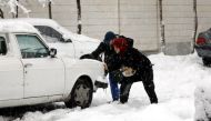 An Iranian couple tries to help a car which is stuck in snow in a street during a heavy snowfall in Tehran, Iran, 28 January 2018. EPA/ABEDIN TAHERKENAREH