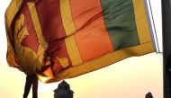 File photo of an air force officer holding Sri Lanka's national flag as the sun sets at Galle Face Green in Colombo February 2, 2013. REUTERS/Dinuka Liyanawatte