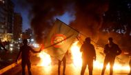 Supporters of Amal movement hold the party's flag near burning tires in Beirut, Lebanon January 29, 2018. REUTERS/Mohamed Azakir