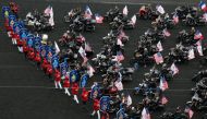 Waving US flags, bikers gets ready to parade on their Harley Davidsons motorbikes prior to the Grand Prix d'Amerique horseracing event on January 28, 2018 at the Vincennes Hippodrome de Paris, in Paris.  AFP / Geoffroy Van Der Hasselt  