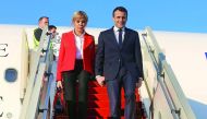 French President Emmanuel Macron (R) and his wife Brigitte Macron descend from an airplane (R) following their arrival at Tunis-Carthage International Airport in Tunis on January 31, 2018. AFP / Zoubeir Souissi