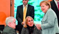 German Chancellor Angela Merkel (R) speaks with Chairman of the Bavarian Christian Social Union (CSU) Horst Seehofer (L) and the Office chief of Bavaria's state chancellery Karolina Gernbauer prior to a meeting with German regional state leaders as part o
