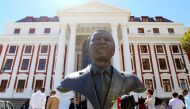 Members of the media are seen behind a bust of Nelson Mandela outside Parliament after it was announced that the State of the Nation address, due to be delivered by President Jacob Zuma, has been postponed, in Cape Town, South Africa, February 6, 2018. Re