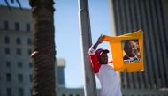 A supporter of South Africa's ruling African National Congress (ANC) holds up a shirt featuring newly-elected ANC president and South African Deputy President, Cyril Ramaphosa, during a rally on February 11, 2018 in Cape Town, from the same spot where exa