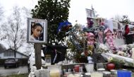 A picture taken on February 15, 2018, in Le Pont-de-Beauvoisin, shows a picture of eight-year-old Maelys de Araujo, candles, toys and messages displayed in tribute to the schoolgirl at the place where was seen for the last time.  AFP / Philippe Desmazes
