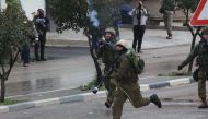 A member of Israeli security fires a tear gas canister to Palestinians during a demonstration, organized to protest Israeli authorities after a Palestinian youth Hamza Zeamire, aged 17, was killed by Israeli security forces, in Hebron, West Bank on Februa