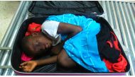 A handout file photo released by the Spanish Guardia Civil shows 8-year-old Ivorian boy Adou Ouattara hidden in a suitcase which was controlled in Ceuta, the Spanish enclave in the north of Morocco, May 08, 2015. AFP PHOTO/ HO/ SPANISH GUARDIA CIVIL