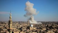 Smoke rises from buildings following bombardment on the village of Mesraba in the rebel-held besieged Eastern Ghouta region on the outskirts of the capital Damascus, on February 19, 2018. AFP / Hamza Al-Ajweh