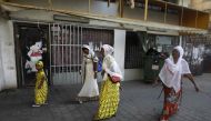 This file photo taken on September 2, 2017 shows Christian African Eritrean migrants walking outside at a makeshift church in southern Tel Aviv.  (AFP / Menahem Kahana) 