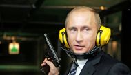 FILE PHOTO: Russian President Vladimir Putin stands with a gun at a shooting gallery of the new GRU military intelligence headquarters building as he visits it in Moscow November 8, 2006. REUTERS
