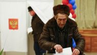 A Russian citizen casts a ballot at a polling station during the presidential election in Bakikonur, Kazakhstan March 18, 2018. REUTERS/Shamil Zhumatov