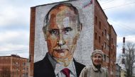 An elderly woman crosses a road in front a mural painting depicting Russian President Vladimir Putin in the town of Kashira, some 115 km southeast of Moscow on October 16, 2017. (AFP / Vasily Maximov) 