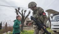 A Turkish soldier chats with a child girl in town center after Turkish Armed Forces and Free Syrian Army (FSA) took complete control of northwestern Syria's Afrin within the 