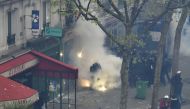 File photo of a French anti-riot police officer protecting himself from smoke grenades during clashes with protesters, April 28, 2016 in Paris (AFP) 