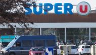 Policemen are at work outside the Super U supermarket of Trebes, southern France on March 23, 2018, after special forces killed a gunman who had taken several people hostages for more than three hours. AFP / Raymond Roig 