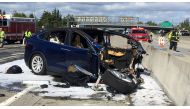 Rescue workers attend the scene where a Tesla electric SUV crashed into a barrier on U.S. Highway 101 in Mountain View, California, March 25, 2018. 