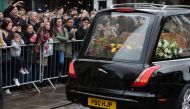 Well-wishers look at the coffin of British scientist Stephen Hawking inside the hearse after the funeral service at the Church of St Mary the Great, in Cambridge on March 31, 2018. AFP / Daniel Leal-Olivas