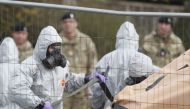 In this file photo taken on March 14, 2018 British military personnel wearing protective coveralls work to remove a vehicle connected to the March 4 nerve agent attack in Salisbury from a residential street in Gillingham, southeast England.  AFP / Adrian 