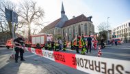 An armed Police officer and first responders are seen at the scene when several people were killed and injured when a car ploughed into pedestrians in Muenster, western Germany on April 7, 2018. AFP / Friso Gentsch