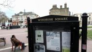 A man sits on a bench next to a sign on Windrush Square in the Brixton district of London, Britain April 16, 2018. REUTERS/Simon Dawson