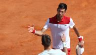 Serbia's Novak Djokovic (up) shakes hands with Croatia's Borna Coric after winning their men's single tennis match at the Monte-Carlo ATP Masters Series Tournament on April 18, 2018 in Monaco. / AFP / VALERY HACHE