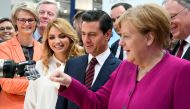 :German Chancellor Angela Merkel fist bumps with a humanoid robot as Mexican First Lady Angelica Rivera de Pena and Mexican President Enrique Pena Nieto look on, at the booth of IBG at Hannover Messe, the trade fair in Hanover, Germany, April 23, 2018. RE