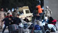 A convoy carrying opposition fighters and their families from the East Qalamun area, 60 kilometres (35 miles) northeast of Syria's capital, arrives in Qalaat al-Madiq, some 45 kilometres northwest of the central city of Hama, on April 23, 2018, after they