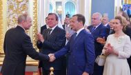 Russian Prime Minister Dmitry Medvedev (3rd L) and German former Chancellor Gerhard Schroeder (2nd L) greet Vladimir Putin (L), who is sworn as Russian President during an inauguration ceremony at the Kremlin in Moscow, Russia May 7, 2018. Alexei Druzhini