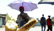 A woman walks past roasted corn for sale in Kenyan capital Nairobi, July 14, 2009. Reuters/Noor Khamis