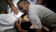The brother of Palestinian Shaher al-Madhoon, who was killed during a protest at the Israel-Gaza border, reacts over his body at a hospital morgue in the northern Gaza Strip May 14, 2018. Reuters/Mohammed Salem