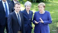 French President Emmanuel Macron (L) Britain's Prime Minister Theresa May( C) and German Chancellor Angela Merkel take a moment to pose for a photograph as they walk together during an EU-Western Balkans Summit in Sofia on May 17, 2018. AFP / LUDOVIC MARI