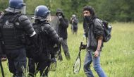 A protester faces French riot gendarmes, during the second eviction of environmental protesters from the area, known as ZAD (Zone a Defendre - Zone to defend) at the site of an abandoned airport project near the western city of Nantes, in Notre-Dame-des-L