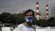 Elpidio dela Cruz, 62, stands in a graveyard adjacent to a 140 megawatt coal-fired power plant in Barangay Lamao in Limay, Bataan, northern Philippines, January 18, 2018. Thomson Reuters Foundation/Alanah Torralba