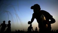  Palestinians run for cover from tear gas shot by Isreali forces during a demonstration along the border between Israel and the Gaza strip, east of Gaza City, on May 25, 2018. / AFP / MOHAMMED ABED
 