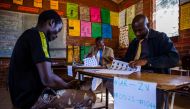 A prospective voter (L) checks her voter registration details with ZEC officials on May 29 2018 at an inspection centre in Harare, ahead of Zimbabwe harmonised 2018 general election, expected for July. AFP / Jekesai NJIKIZANA