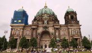 People sit in front of the Berliner Dom after a German policeman shot a man at the Berlin Cathedral, German media reported in Berlin, Germany, June 3, 2018. REUTERS/Fabrizio Bensch