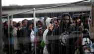Migrants with their belongings stand in line as French police evacuate hundreds of migrants living in makeshift camps in Paris, France, May 30, 2018. REUTERS/Benoit Tessier