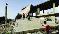 Syrian children play among destroyed buildings in Kobane on May 27, 2018.  AFP / Delil souleiman