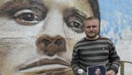 Russian street artist Sergey Erofeev poses next to his mural depicting Argentina's football star Lionel Messi in Bronnitsy near Moscow on June 9, 2018, ahead of the Russia 2018 World Cup.  AFP / Juan Mabromata